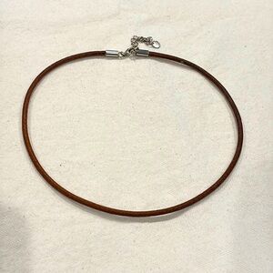 Brown leather choker — very thin — with silver (925) clasp.